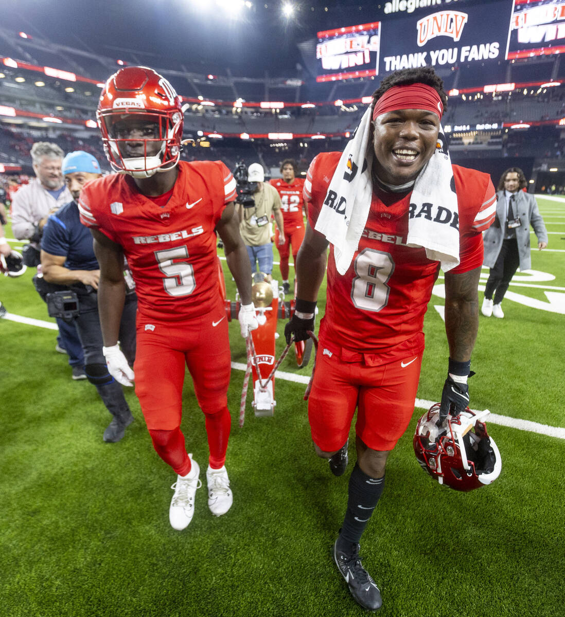 UNLV running back Greg Burrell (5) and linebacker Marsel McDuffie (8) wheel the Fremont Cannon ...