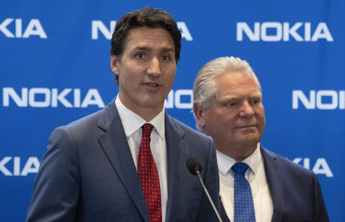 FILE - Prime Minister Justin Trudeau, left, responds to a question as Ontario Premier Doug Ford ...