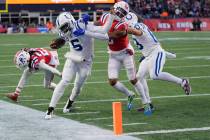 Indianapolis Colts quarterback Anthony Richardson (5) pushes away New England Patriots cornerba ...