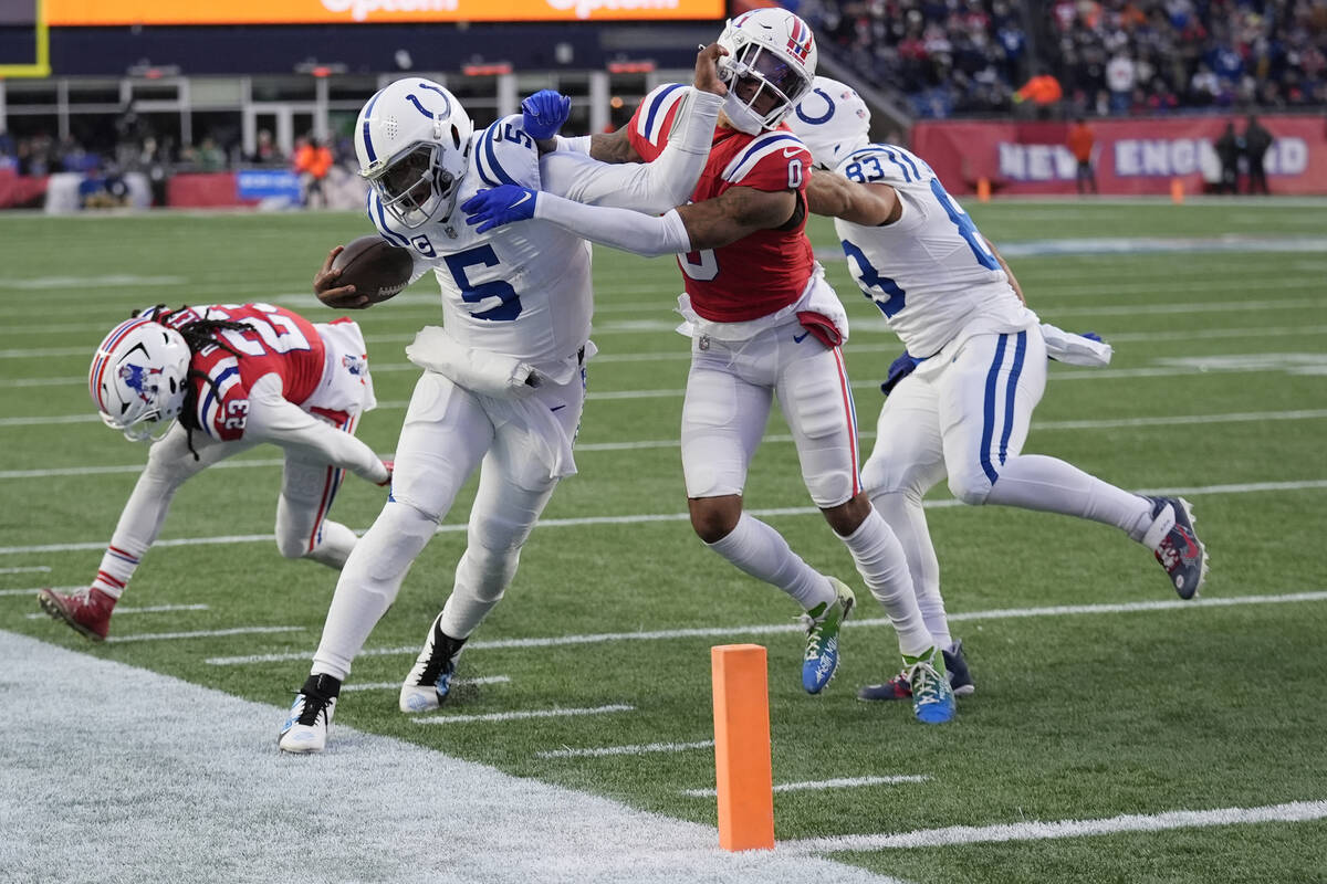 Indianapolis Colts quarterback Anthony Richardson (5) pushes away New England Patriots cornerba ...