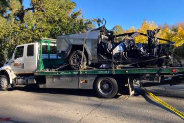 A tow truck removes the charred remains of a Tesla Cybertruck that crashed, killing three peopl ...