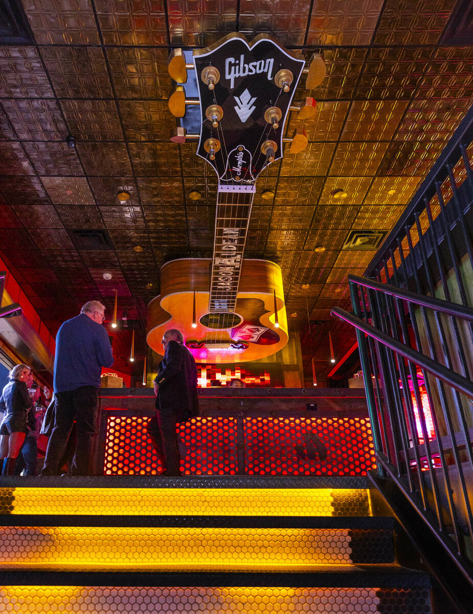 A giant Gibson guitar hangs above an upstairs bar within the new Jason Aldean’s Kitchen ...