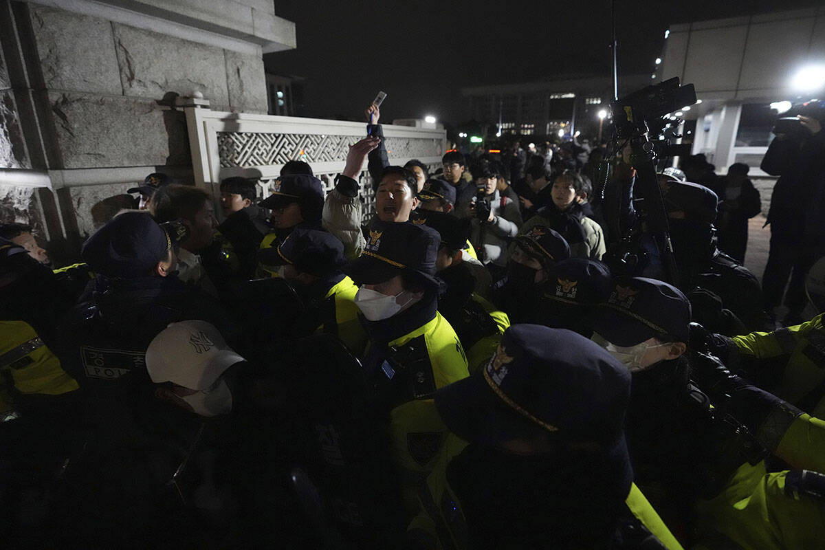 Police officers stand guard in front of the National Assembly in Seoul, South Korea, Tuesday, D ...