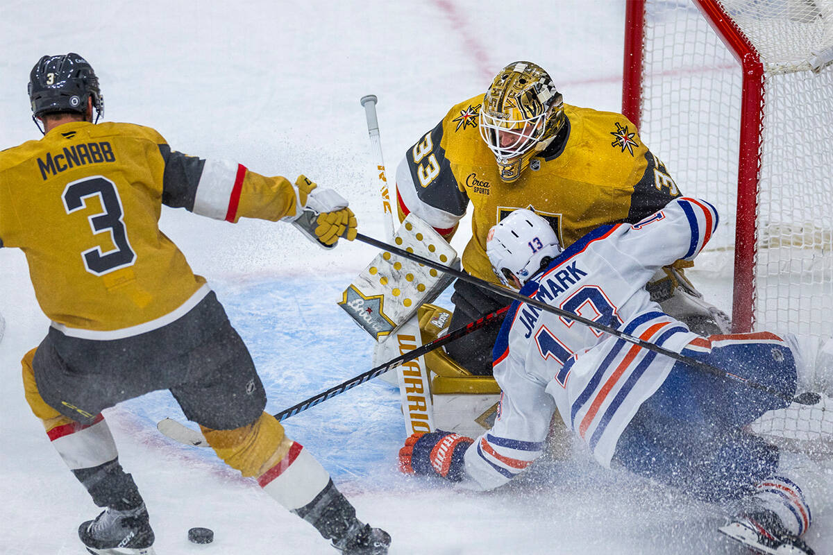 Golden Knights goaltender Adin Hill (33) deflects away a shot as Edmonton Oilers center Mattias ...