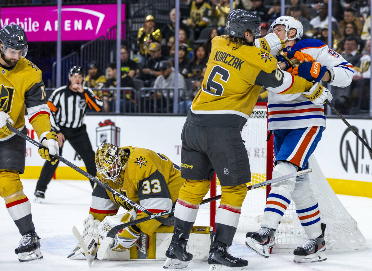 Golden Knights defenseman Kaedan Korczak (6) gives Edmonton Oilers right wing Corey Perry (90) ...