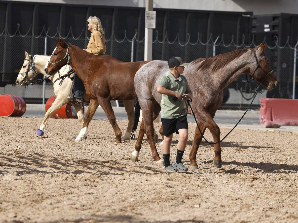 Monique Michel of Las Vegas, left, and Gage Pressinger, 10, warm up their horses at the Core Ar ...