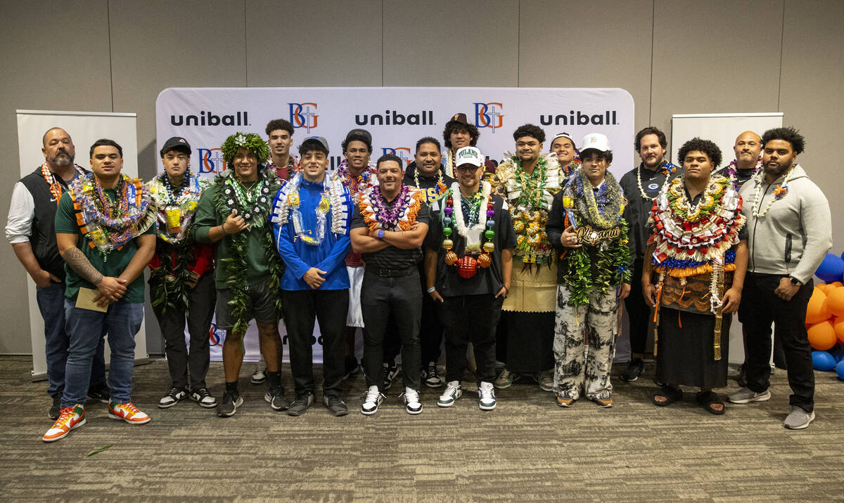 12 Bishop Gorman signees and some coaches take a group photograph after the Signing Day ceremon ...