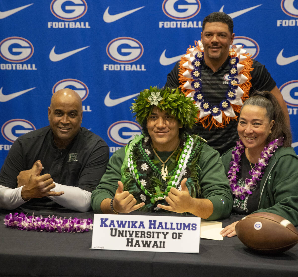 Bishop Gorman’s Kawika Hallums, center, signs a financial aid agreement with the Univers ...