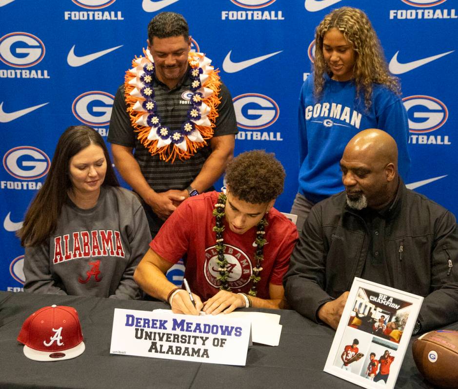 Bishop Gorman wide receiver Derek Meadows, center, signs a financial aid agreement with the Uni ...