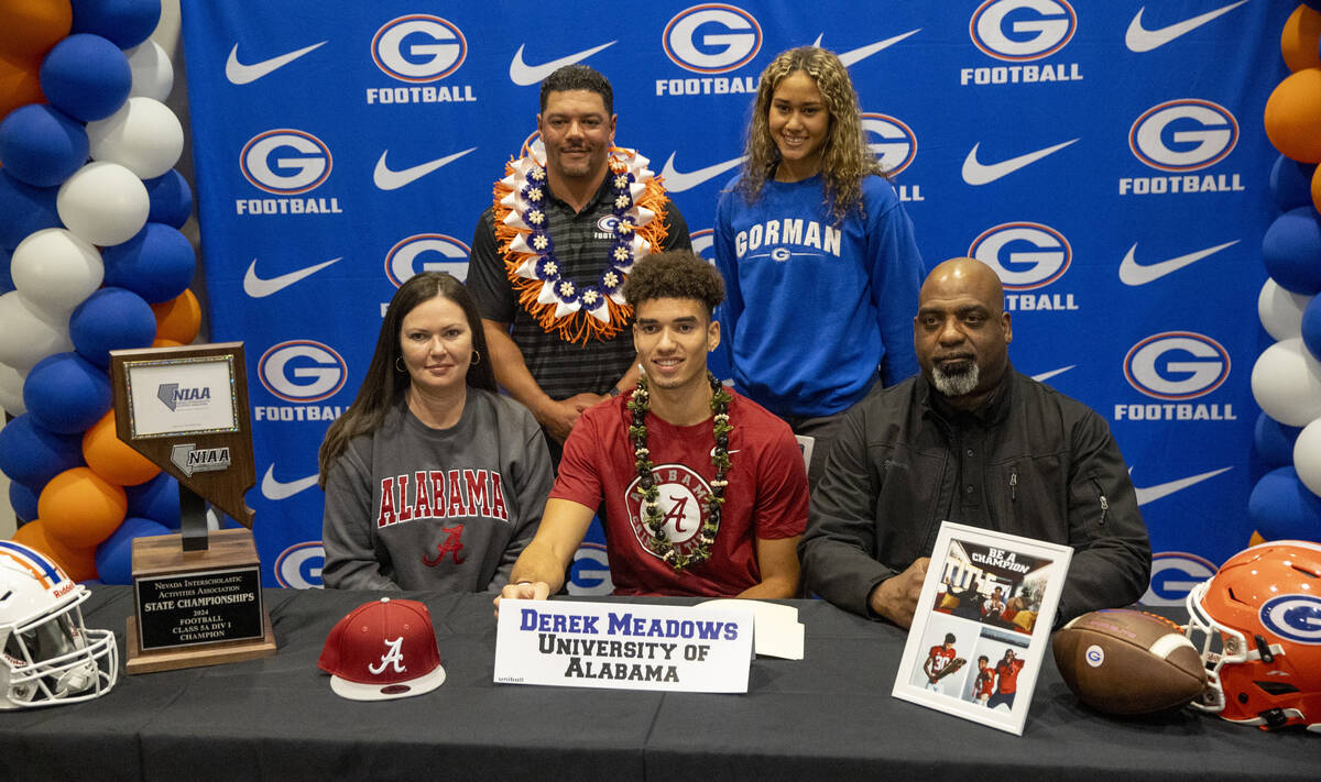 Bishop Gorman wide receiver Derek Meadows, center, signs a financial aid agreement with the Uni ...