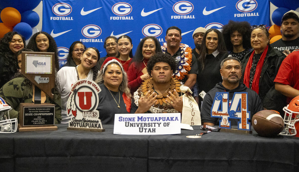 Bishop Gorman defensive tackle Sione Motuapuaka, center, signs a financial aid agreement with t ...