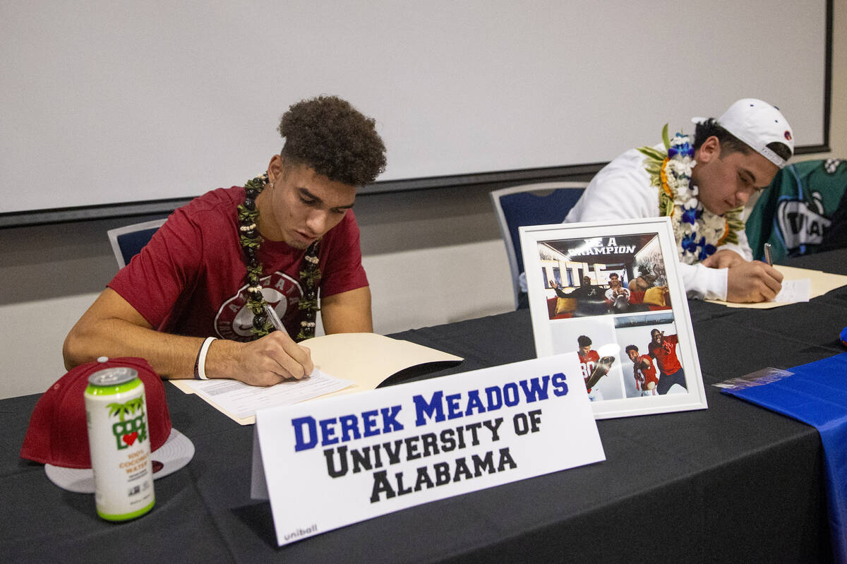 Bishop Gorman wide receiver Derek Meadows, left, signs a financial aid agreement with the Unive ...