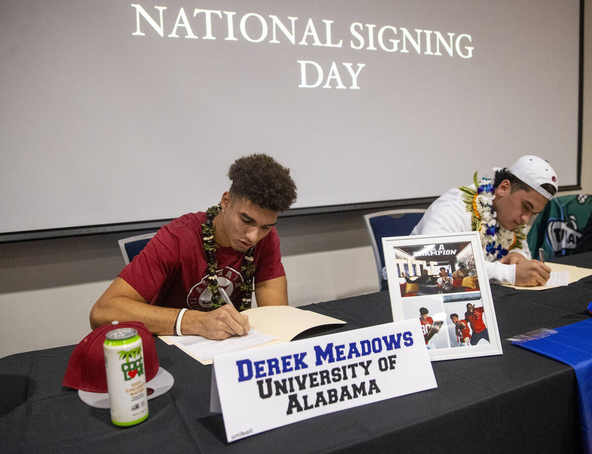 Bishop Gorman wide receiver Derek Meadows, left, signs a financial aid agreement with the Unive ...