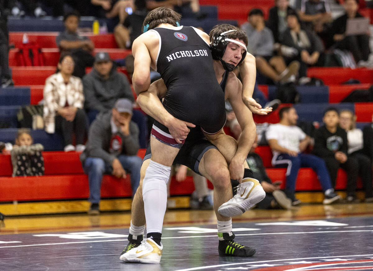 SLAM Academy’s Drake Hooiman, back, begins to pick up Liberty’s Wyatte Nicholson, ...