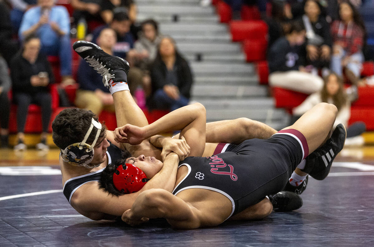 SLAM Academy’s Santiago Cabrera, left, places Liberty’s Alan Hayes, right, into a ...