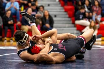 SLAM Academy’s Santiago Cabrera, left, places Liberty’s Alan Hayes, right, into a ...