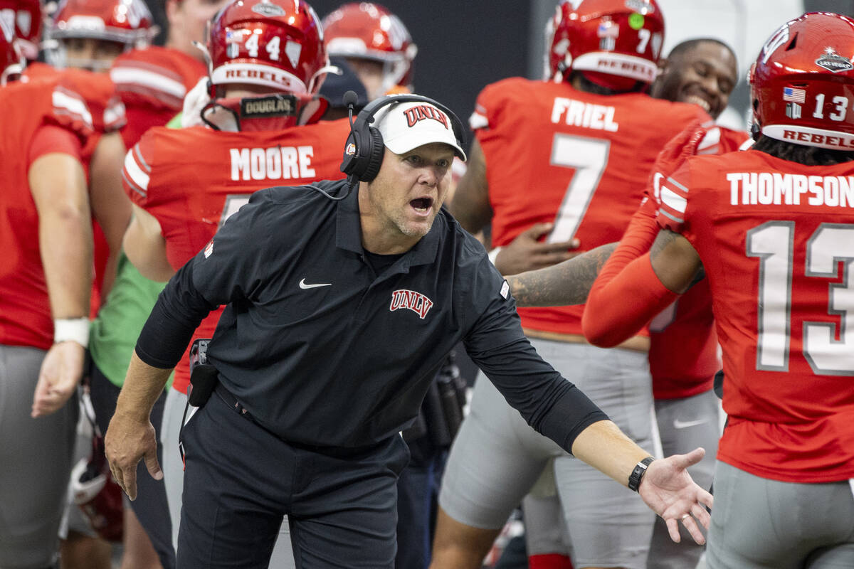 UNLV head coach Barry Odom welcomes players back to the sideline after scoring a touchdown duri ...