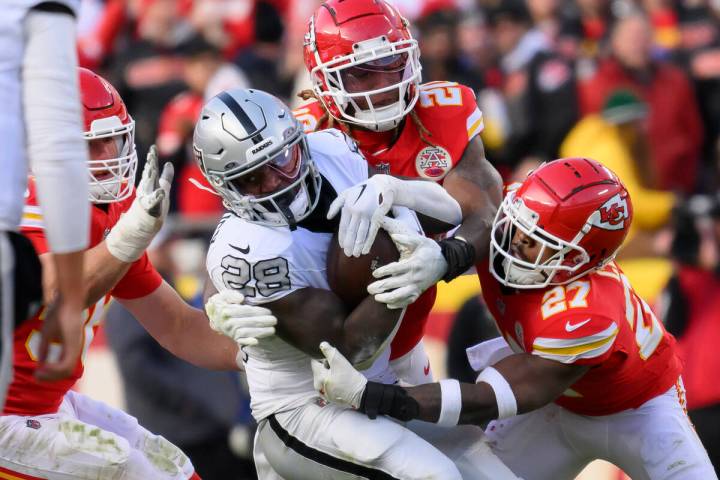 Las Vegas Raiders running back Sincere McCormick (28) is tackled by Kansas City Chiefs safety C ...