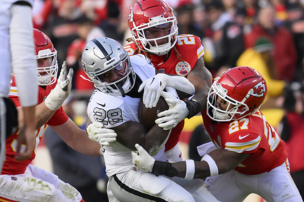 Las Vegas Raiders running back Sincere McCormick (28) is tackled by Kansas City Chiefs safety C ...