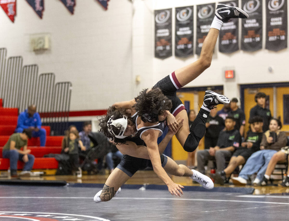 SLAM Academy’s Destin Maestas, left, tosses Liberty’s Diego Acosta, right, during the high ...