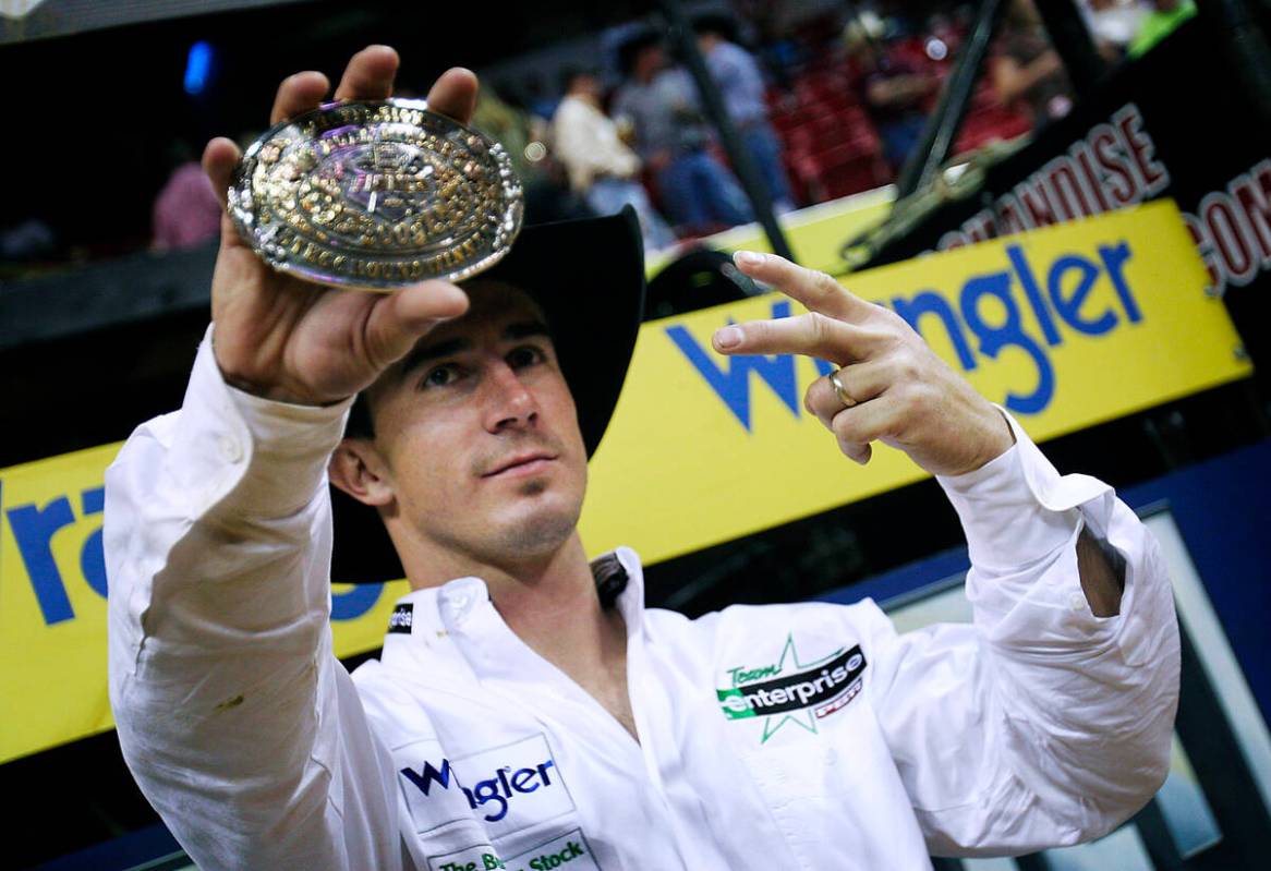 After winning the fourth and fifth round of the PBR World Finals, Kody Lostroh holds up a belt ...