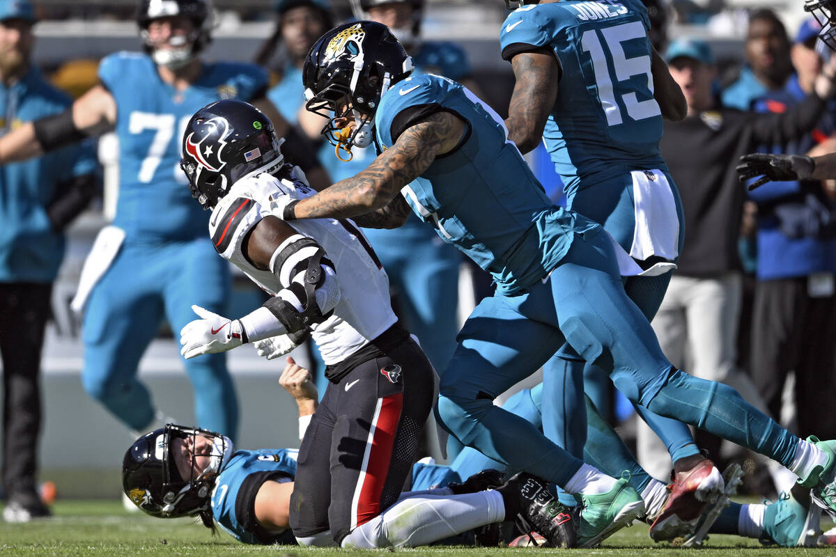 Jacksonville Jaguars tight end Evan Engram (17, right) jumps on Houston Texans linebacker Azeez ...