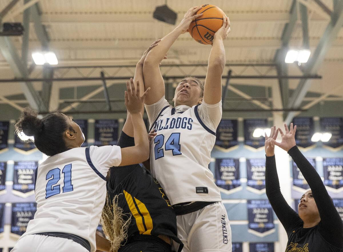 Centennial sophomore Nation Williams (24) reaches for a rebound during the high school girls ba ...