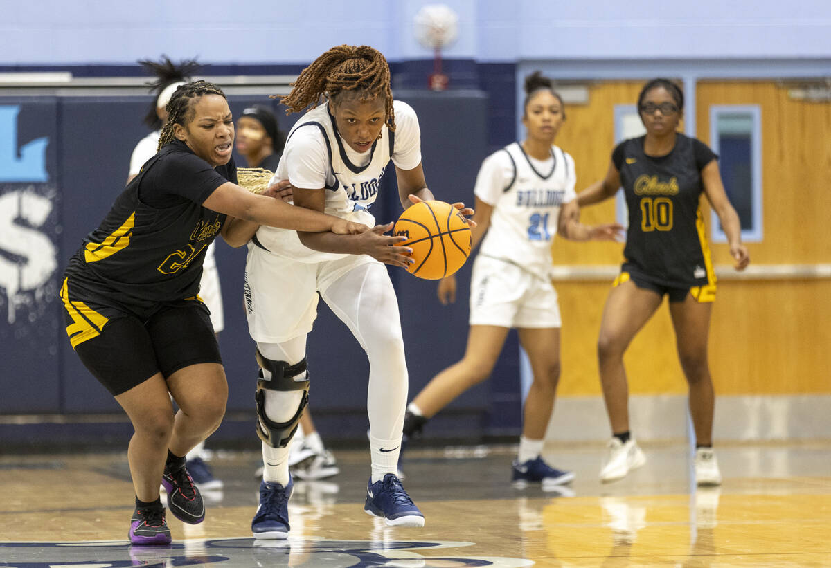 Centennial junior Inieye Oruh, right, steals the ball from Clark’s Paradise Norsworthy, left, ...