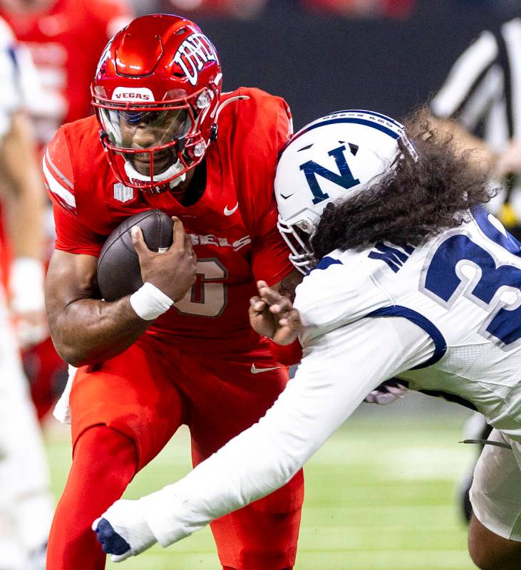 UNLV quarterback Hajj-Malik Williams, left, winces while being tackled by UNR linebacker Tongia ...