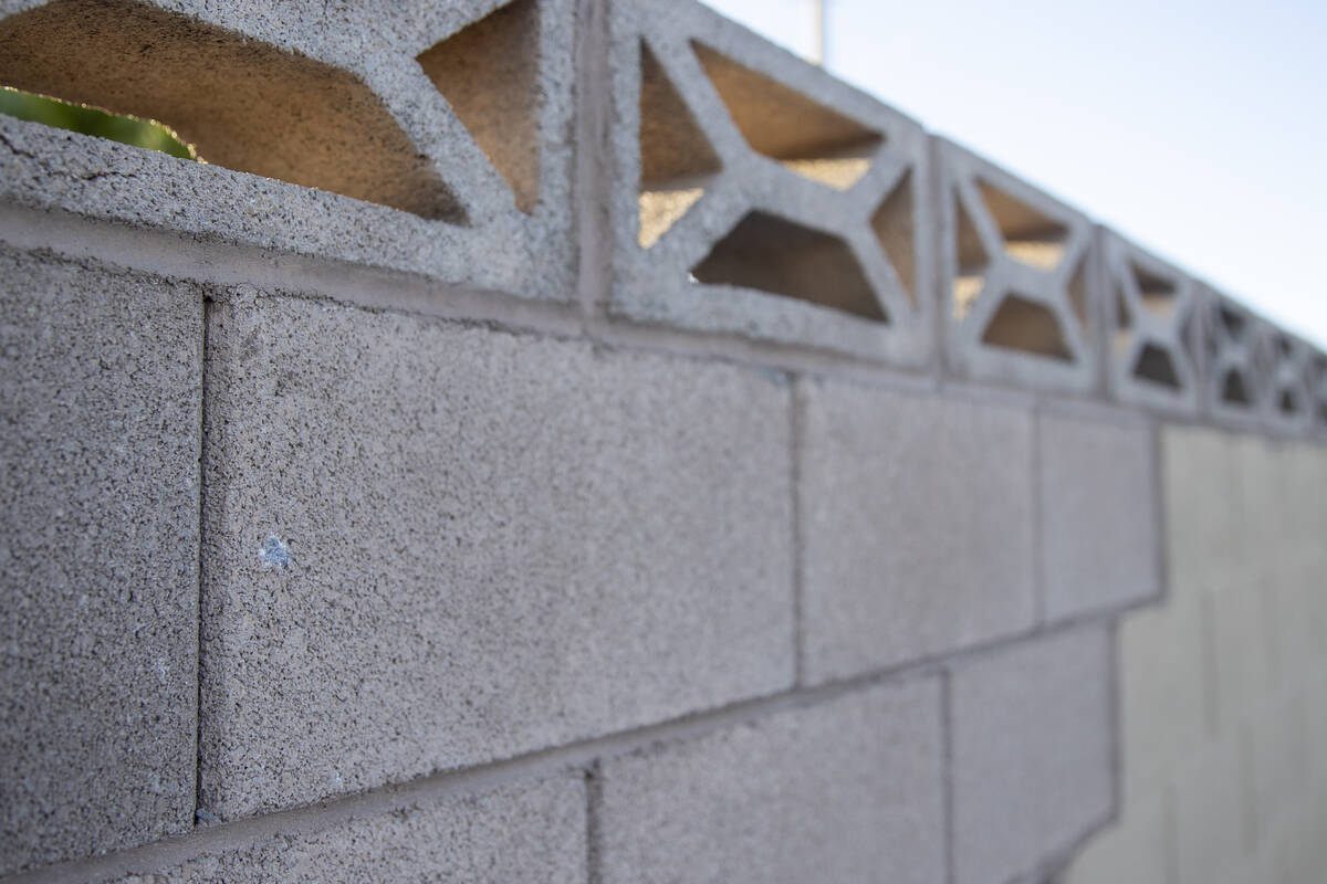 An indent from a bullet marks a wall outside of a home at the intersection of East Hacienda Ave ...