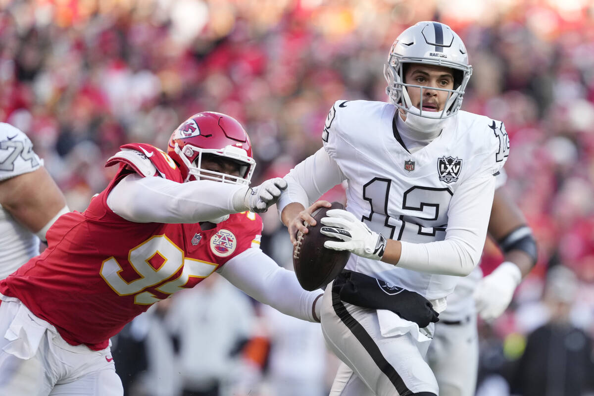 Las Vegas Raiders quarterback Aidan O'Connell (12) avoids a tackle by Kansas City Chiefs defens ...