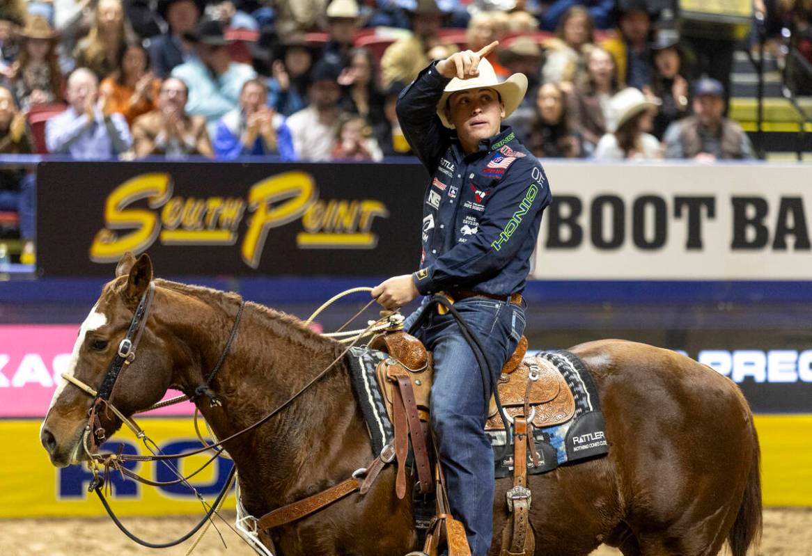 Riley Mason Webb points to the crowd after competing in the tie-down roping event during openin ...