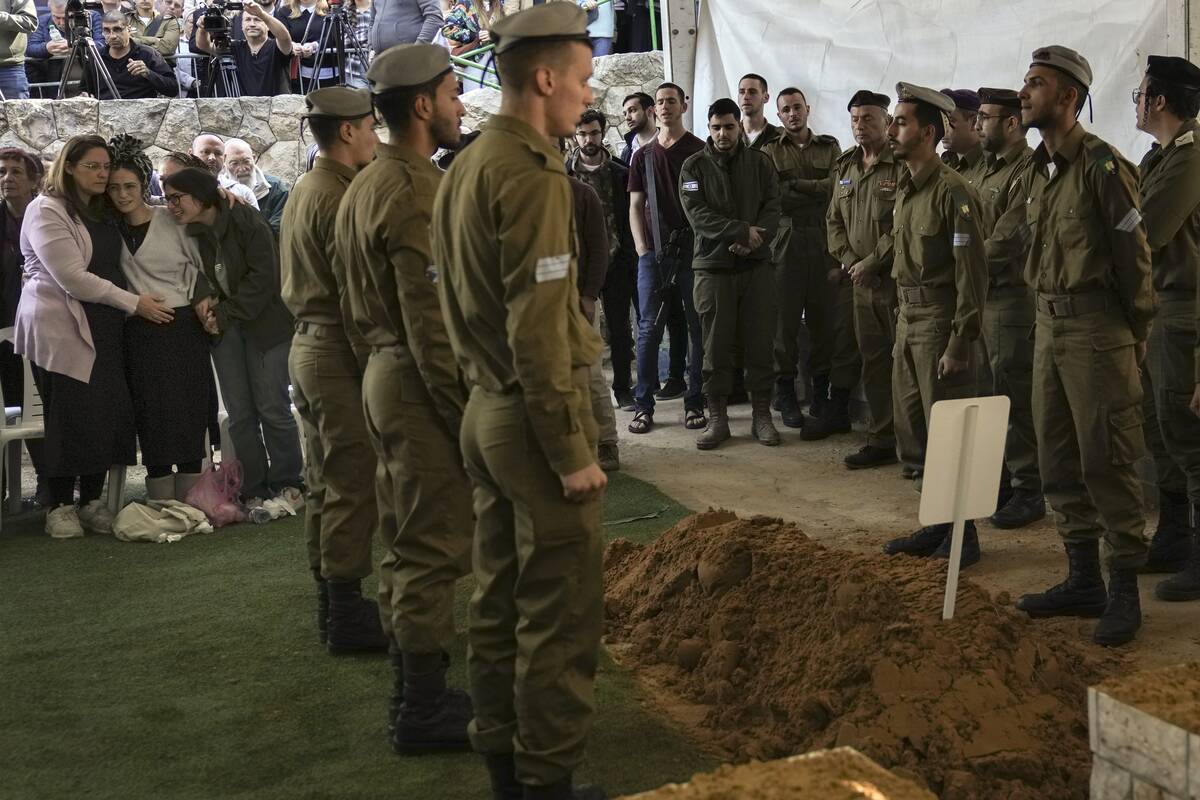 Close relatives, left, of combat engineer squad commander Staff Sgt. Zamir Burke, 20, from Beit ...