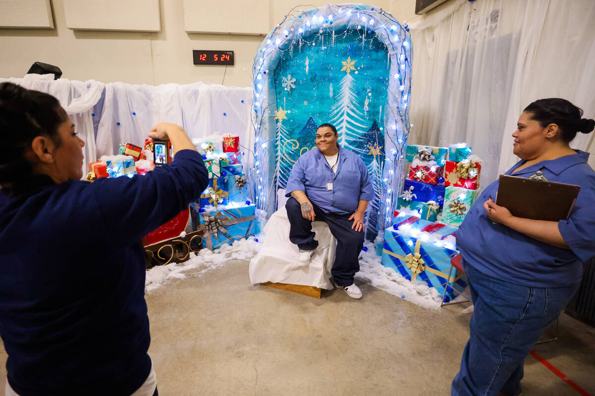 Gladys Perez, left, takes photographs of inmates at a photo backdrop she made during an event t ...