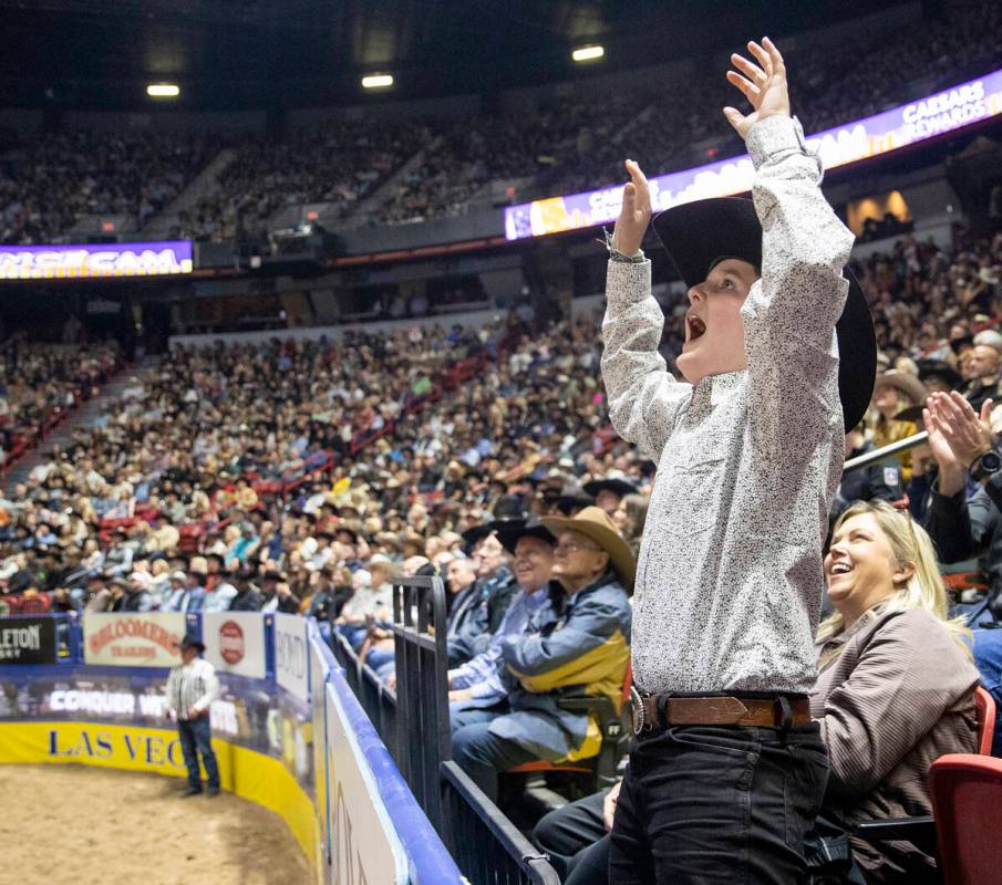 A young fan celebrates after seeing himself on the big screen during opening night of the Natio ...