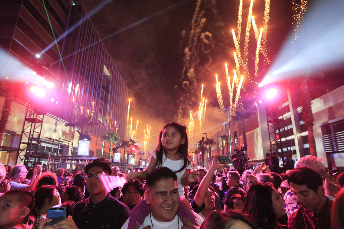 Anika Begay sits on her father Brian Begay's shoulders while watching a light and fireworks sho ...