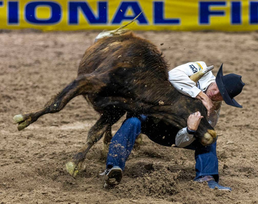 Steer wrestler Rowdy Parrott wraps up his steer for a take down during National Finals Rodeo Da ...