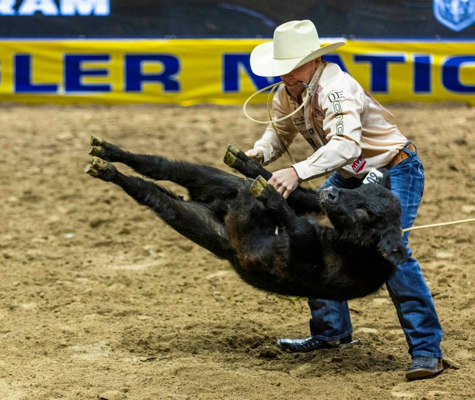 Tie-Down Roping competitor Riley Webb upends his calf on the way to a winning time during Natio ...