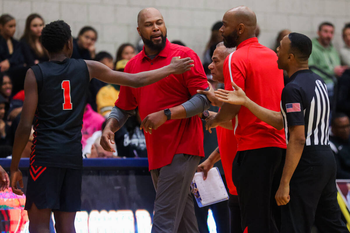 Mater Academy head coach Antoine Wright is escorted away from a referee by his coaching staff a ...