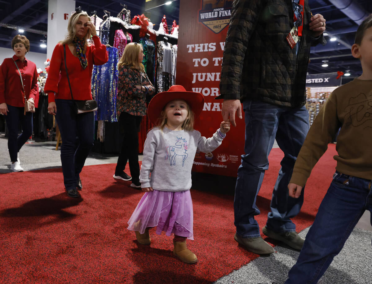 Rainey Wingo, 2, holds on to her father, Will, of Texas, as they shop at Cowboy Christmas at th ...