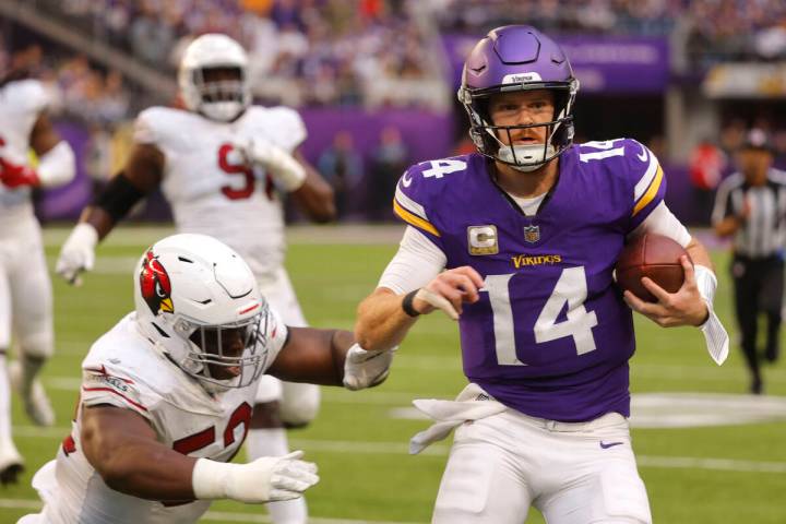 Minnesota Vikings quarterback Sam Darnold (14) runs from Arizona Cardinals linebacker Victor Di ...