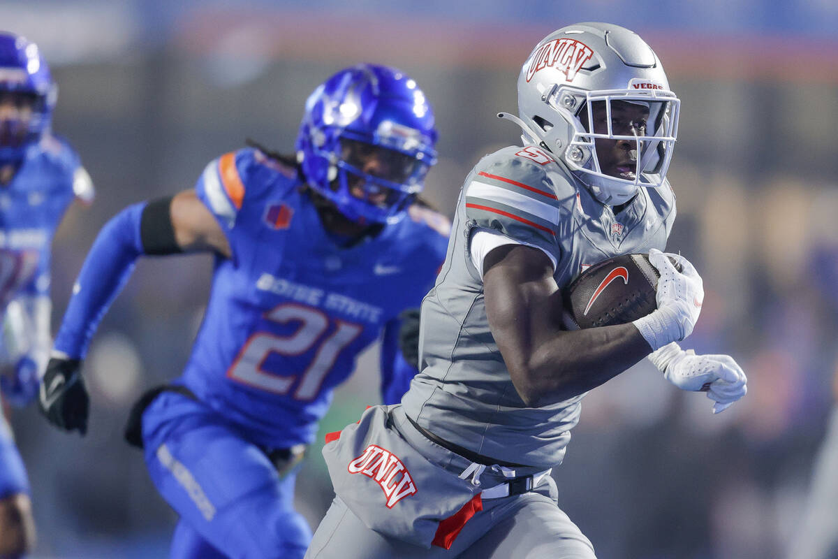 UNLV running back Greg Burrell (5) runs away from the Boise State defense for a touchdown in th ...