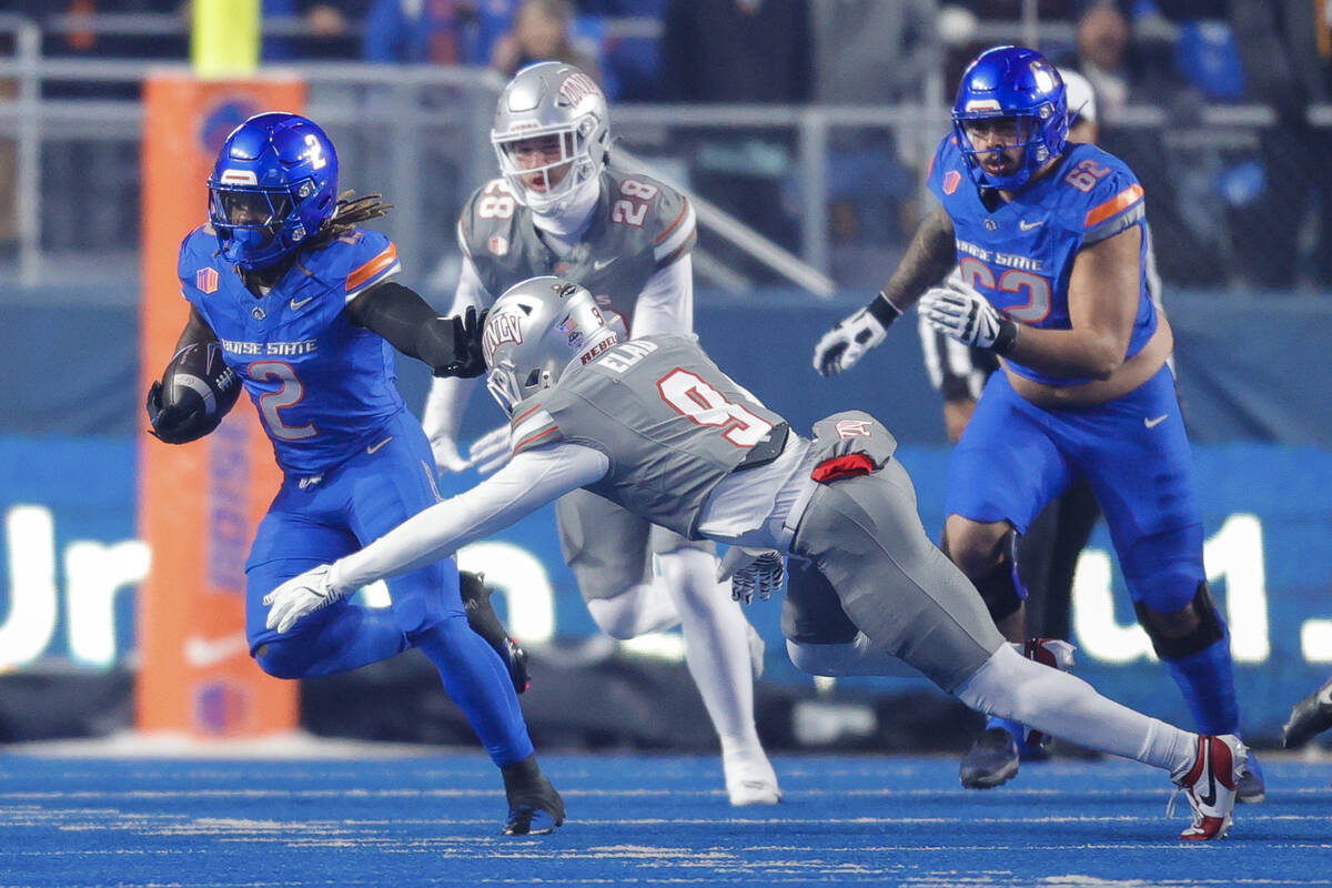 Boise State running back Ashton Jeanty (2) stiff-arms UNLV defensive back Jett Elad (9) on a ru ...