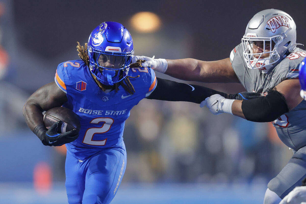 Boise State running back Ashton Jeanty (2) pushes away from the arms of UNLV defensive lineman ...