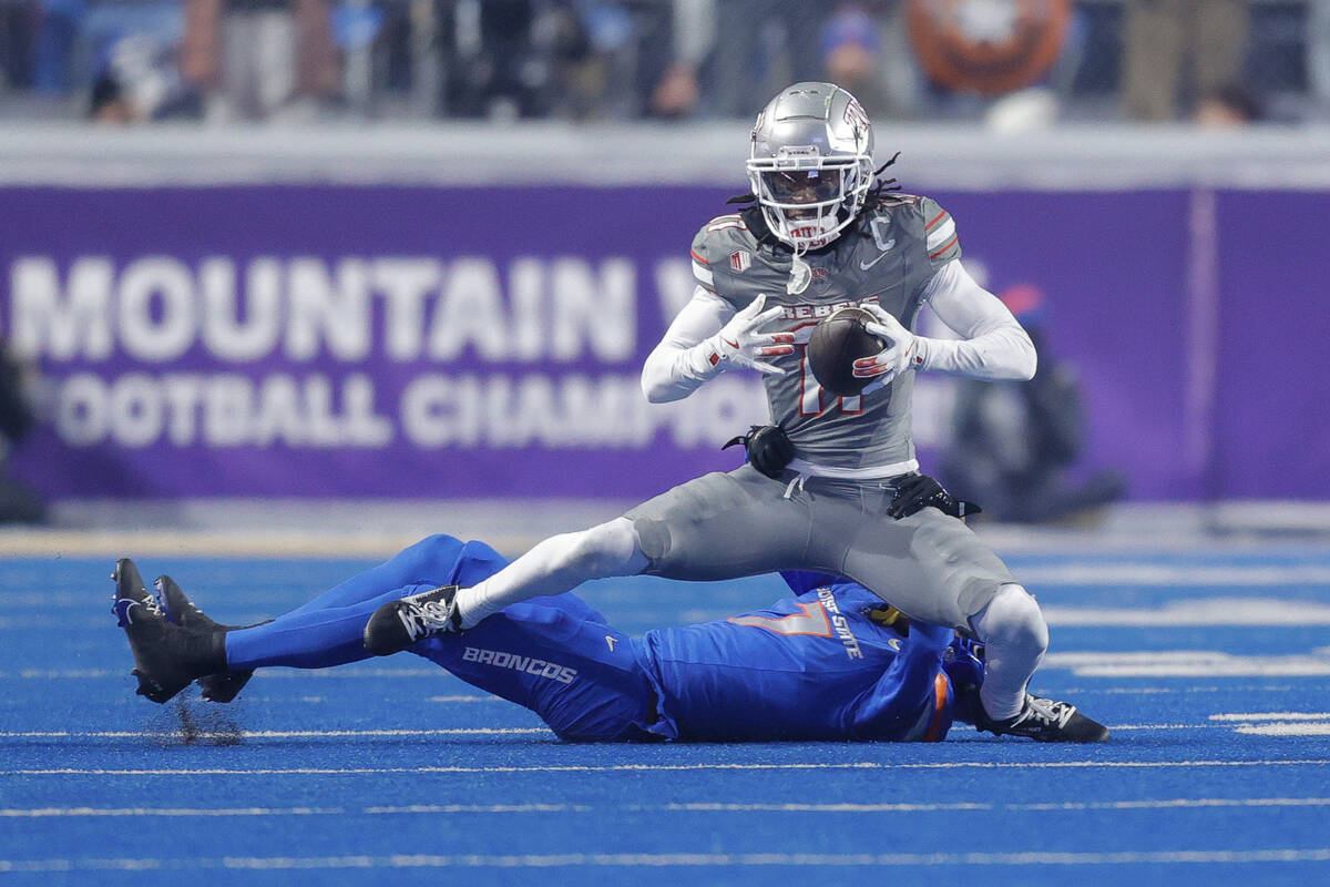 UNLV wide receiver Ricky White III (11) is pulled down after a reception by Boise State cornerb ...