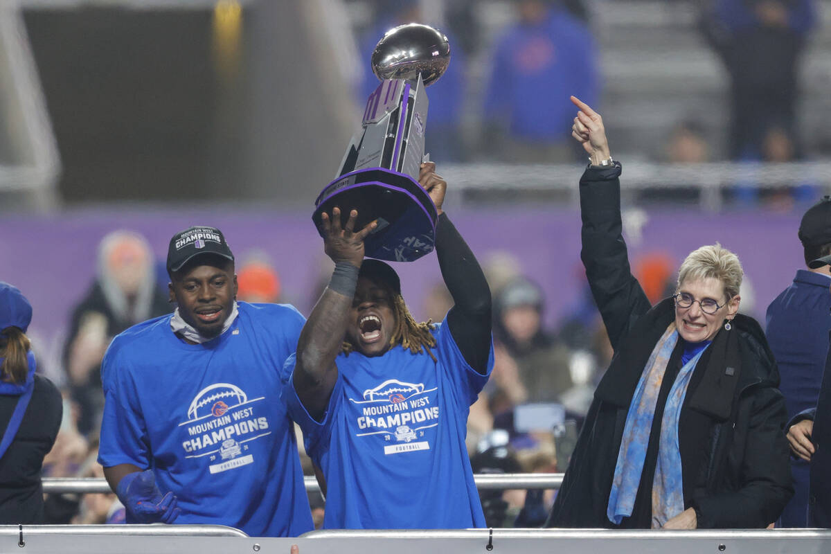 Boise State running back Ashton Jeanty, center, holds up the Championship Trophy celebrating wi ...