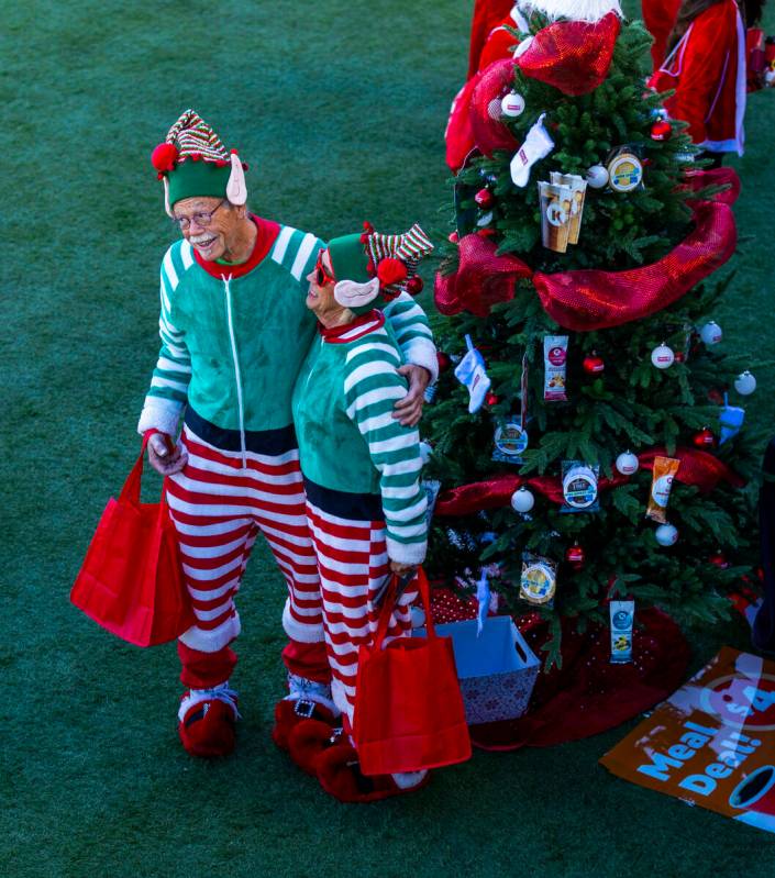 A couple of elves gather near a decorated tree at the Downtown Las Vegas Events Center before t ...