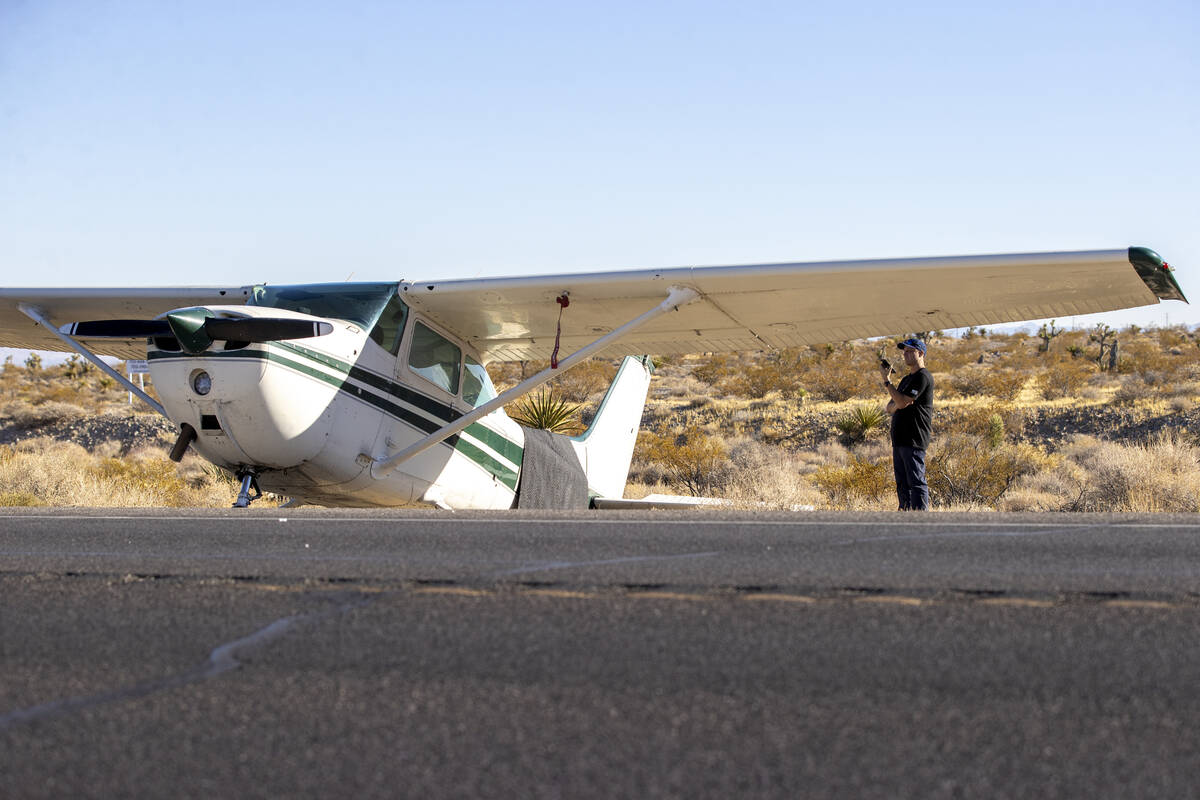 A man, who declined to give his name, talks on the phone after a plane emergency landed on Kyle ...