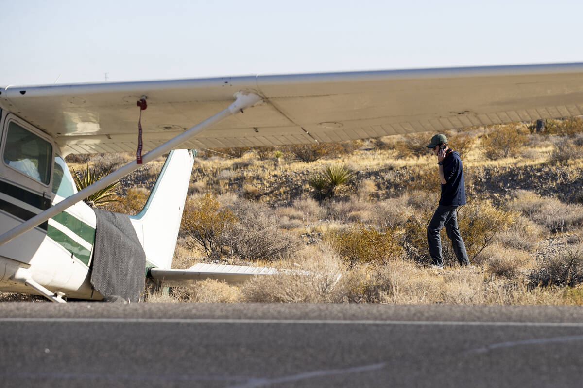 A man, who declined to give his name, talks on the phone after a plane emergency landed on Kyle ...