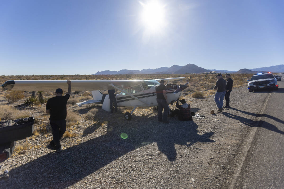 A crew of men, who declined to give their names, work on a plane after it emergency landed on K ...